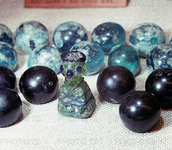 Semi spherical glass gaming pieces and a king of green glass with blue eyes, nose and crown