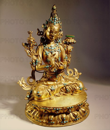 A statue of Manjusri, Bodhisattva of Wisdom, with the sword that destroys ignorance on the lotus at his right shoulder, and the book of wisdom at his left