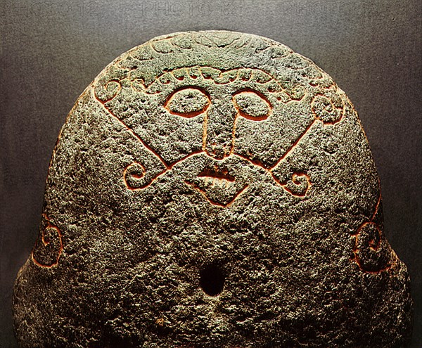 Detail of a forge stone incised with the face of the god Loki with lips sewn together