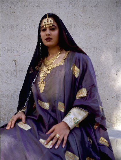 A woman wearing impressive gold jewellery and traditional costume