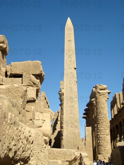 The obelisk raised by Tuthmosis II with the Great Hypostyle Hall in the background and a carved "ankh" symbol in the foreground