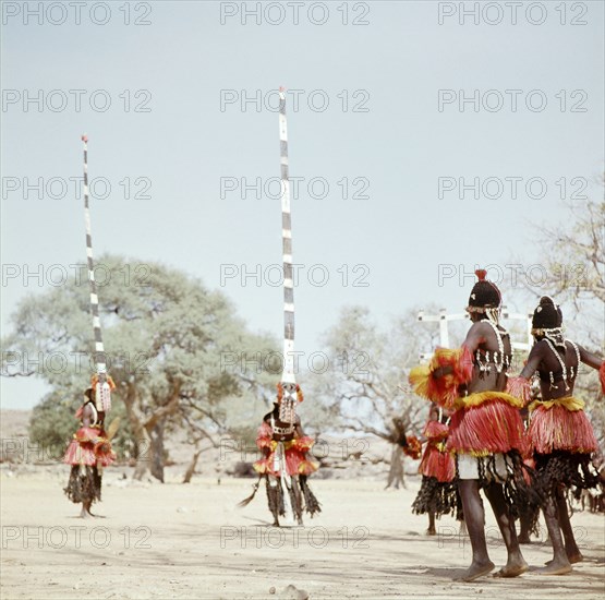 Dogon masqueraders perform in a ceremony known as a dama, which draws the souls of honoured dead away from the village and brings prestige to their families