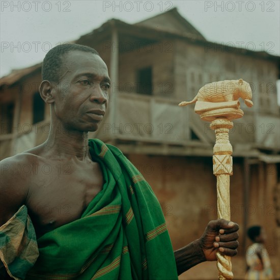 An Ashanti 'speaker' holding his staff of office, a local adaptation of staffs introduced by European traders on the Gold Coast since the C 16th