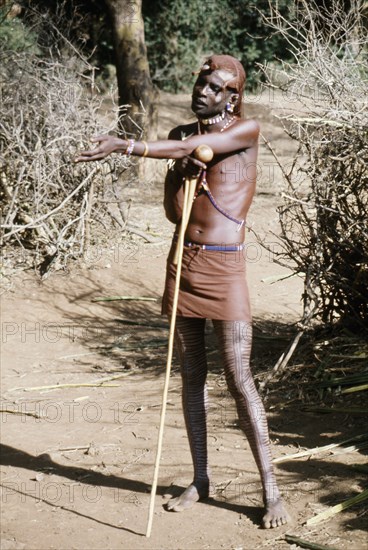 The hairstyle and beadwork of this Masai man indicate his status as a warrior