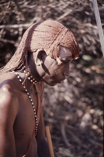 The hairstyle and beadwork of this Masai man indicate his status as a warrior