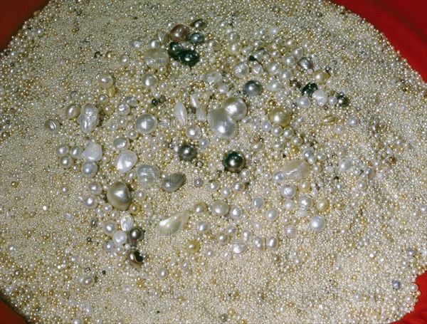 Light gleams on a vast circular mound of pearls