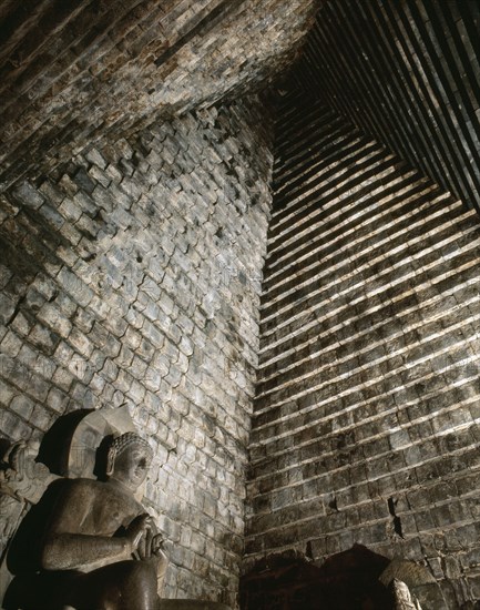 A statue of the seated Buddha in Chandi Mendut, one of the several temples associated with Borobudur