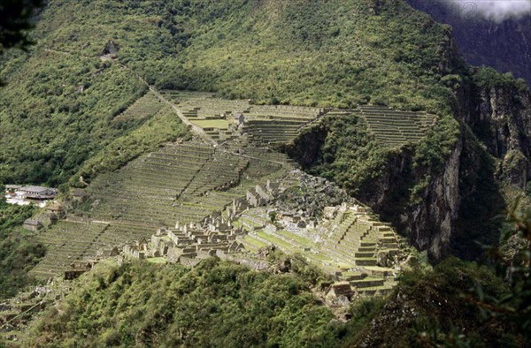 View of Machu Picchu from the summit of Huayna Picchu, showing the dramatic location of the city and its terrace system