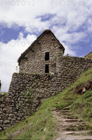 View of an Inca house at Machu Picchu with reconstructed thatched roof