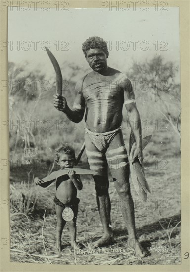 Aboriginal man and a child holding boomerangs