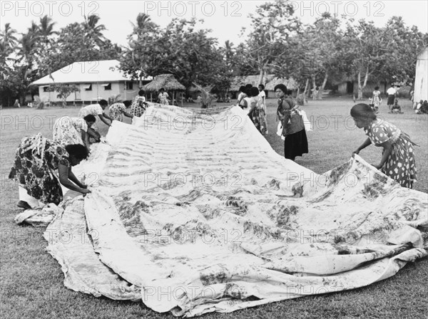 Laying out a 'masi' cloth