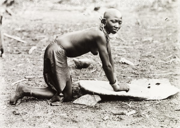 Kikuyu woman grinding millet