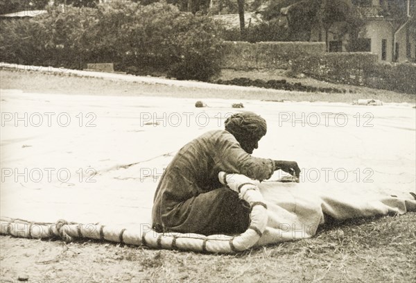 Sail maker repairing a dhow