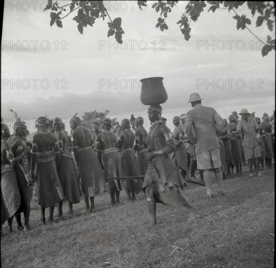 Woman going to inyangi, in front of ch. J. and dancers