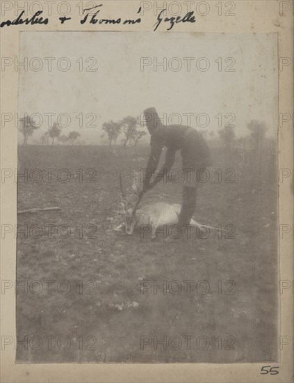 Uniformed servant with dead Thomson's gazelle