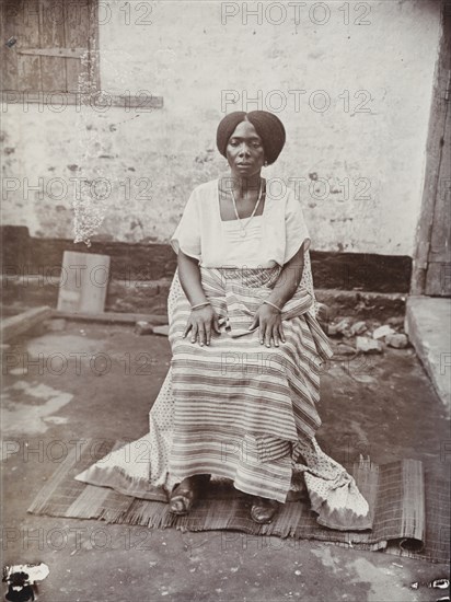 Portrait of a seated Nigerian woman wearing traditional dress