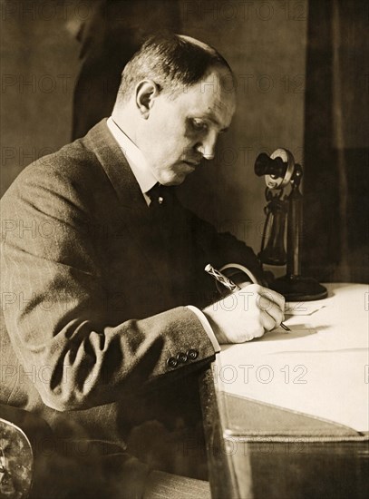 Man Writing At HIs Desk