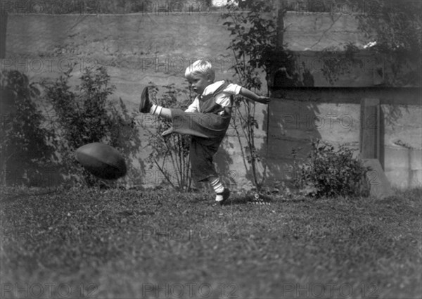 A Small Boy Kicking Football