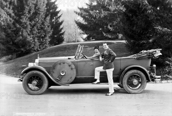 A Couple Poses By Their Car