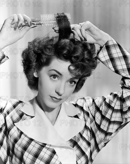 Woman Brushing Curls In Her Hair