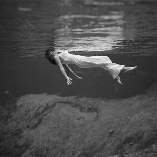 Weeki Wachee, Florida: 1947.
An underwater fashion photograph of a woman, wearing a long gown, floating on her back at the Weeki Wachee Spring in Florida.