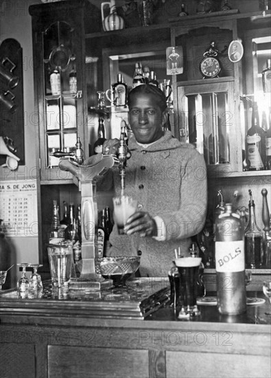 Amsterdam, Netherlands: 1928.
Uruguayan soccer star Andrade pouring a draft beer into a mug for his teammates.