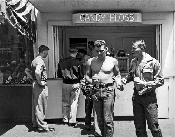 San Francisco, California:  c. 1955.
Two young men walk past a cotton candy stand with snow cones in their hands at Playland At The Beach in San Francisco.