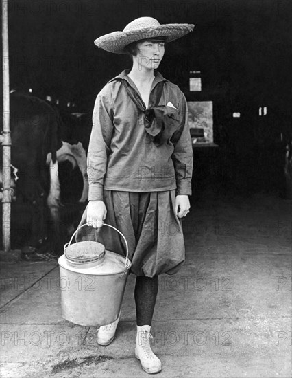 United States:  c. 1905.
A young teenage girl leaving the barn with a bucket of fresh milk.