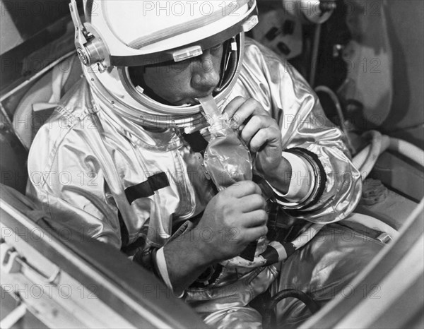 Houston, Texas:  March, 1966.
A NASA test subject consumes a meal of pot roast and gravy through a feeding tube pack aboard a Gemini spacecraft mockup.