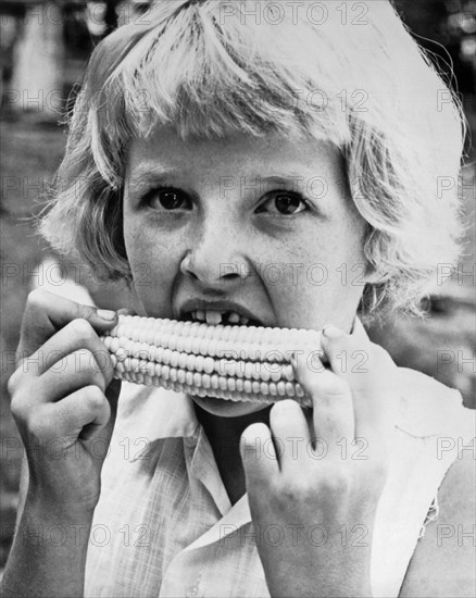 Coon Rapids, Iowa:  July 27, 1962.
A nine year old girl with a missing front tooth eats sweet corn on the cob.