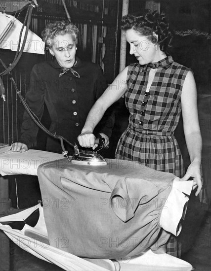 A Woman Irons A Shirt