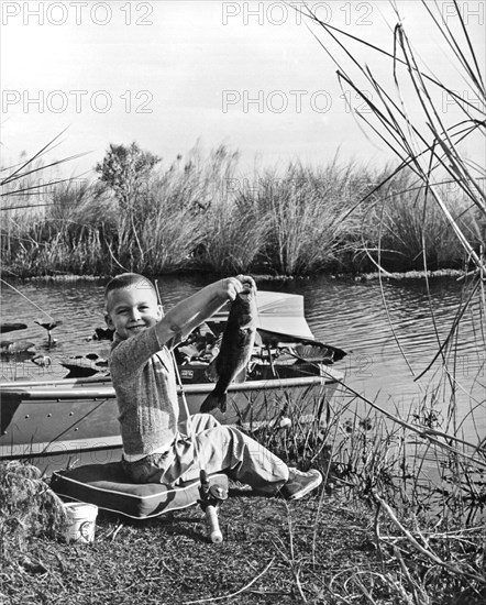 A Boy Holds Up His Catch