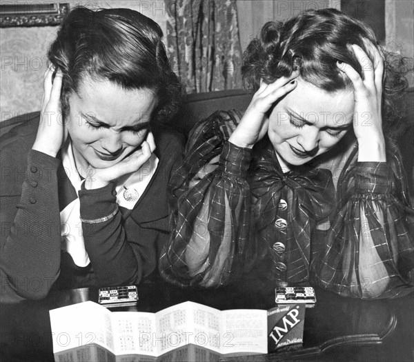 Detroit, Michigan:  January 30, 1934.
Two women apply their thinking power to the new fad, the Imp puzzle game.