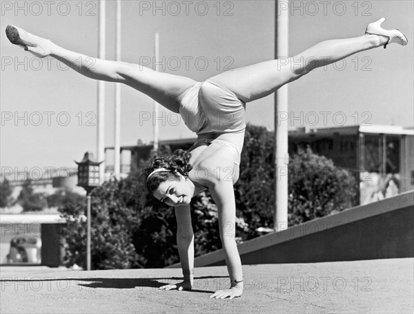 Sally Rand combines a hand stand with the splits