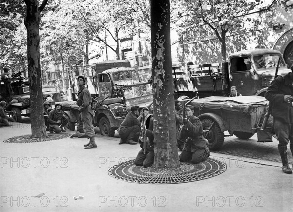 Paris, France:   August 28, 1944.
French soldiers of the 2nd Amored Division scan the rooftops of Paris for a source of sniper fire.