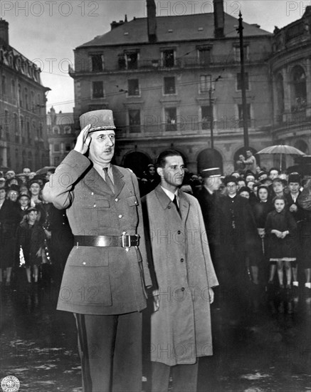 Rennes, France:  August 21, 1944.
General Charles de Gaulle salutes in the town square of Rennes, France, the capital of Brittany, as the French national anthem is being played. He spoke to a great throng of citizens who stood in a pouring rain to listen to him.