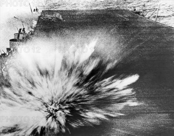 A Japanese bomb explodes on the flight deck of the USS Enterprise, killing the photographer, Phom 3/c Robert Read, but the film survived.