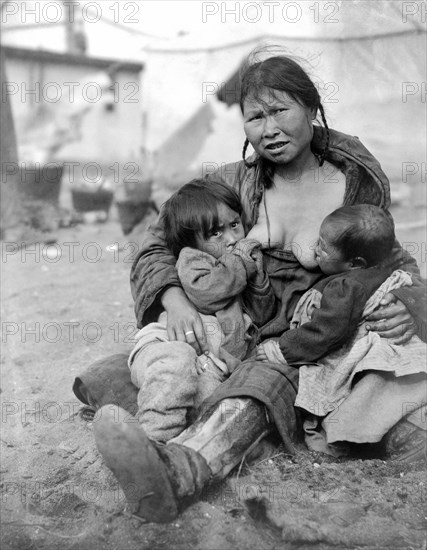 Alaska, United States: 1904.
An Inuit Eskimo woman breast-feeding two babies.