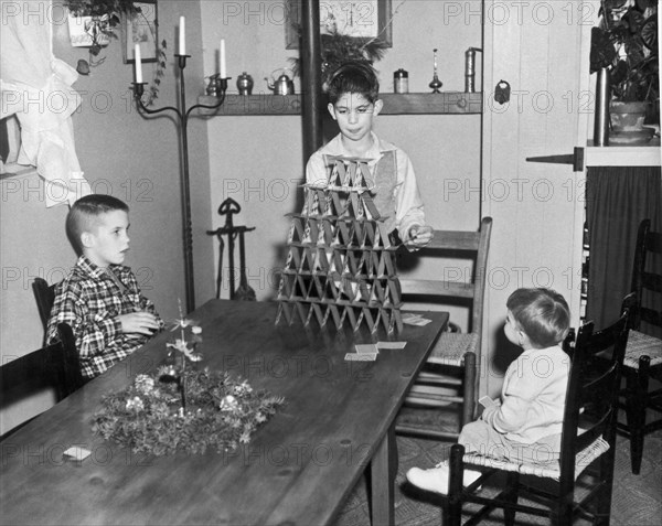 Boy Making A Pyramid Of Cards