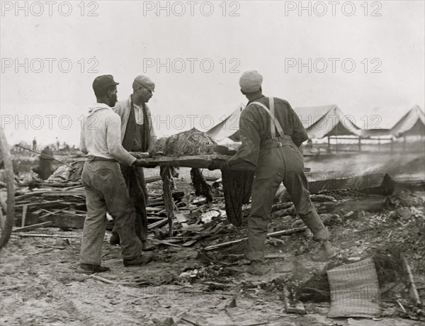 Galveston disaster, carrying dead body to fire to be burned 1900