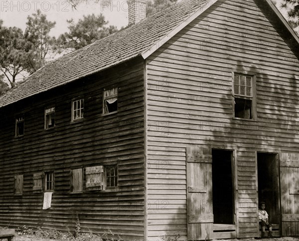 Exterior of one of the shacks containing 24 rooms. 1910