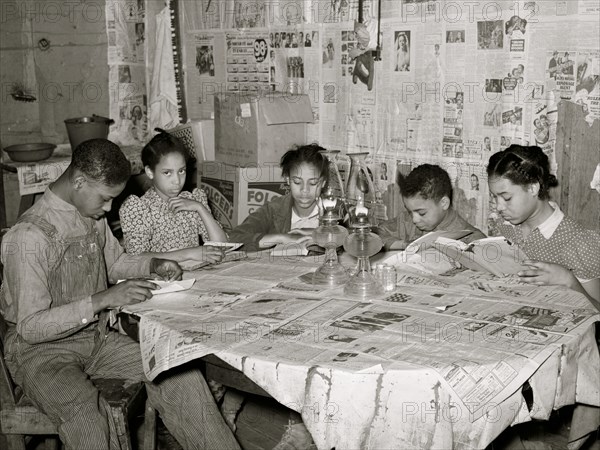 Five children of Pomp Hall, Black tenant farmer, studying their lessons by lamplight. Creek County, Oklahoma. 1938