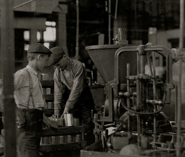 A canning machine and some of the boys] Small boys work at and around these machines some of which[?][ are dangerous.  1909