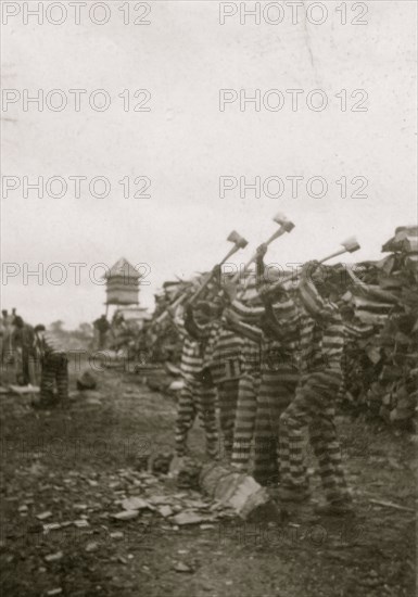 African American convicts working with axes, watchtower in background, Reed Camp, South Carolina 1934