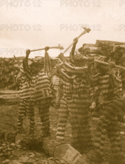 African American convicts working with axes, watchtower in background, Reed Camp, South Carolina 1934