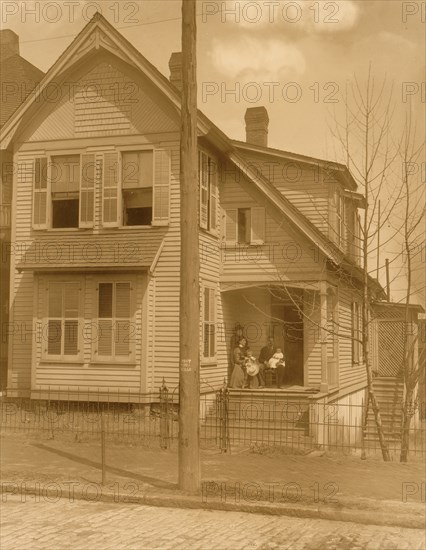 African American family posed on porch of house 1899
