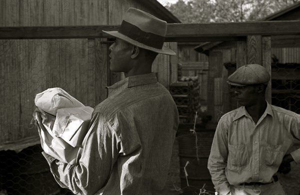 African American in hat carries packages 1935