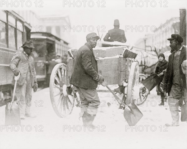 African American men shoveling snow in street, Washington, D.C 1915