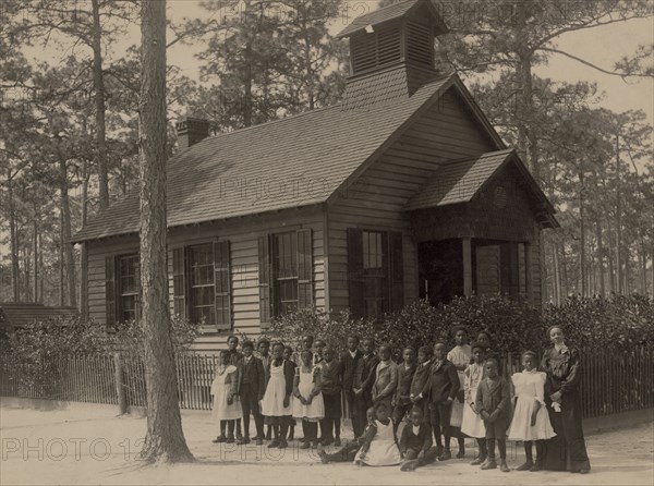 African American school children posed with their teacher outside a school, possibly in South Carolina 1905