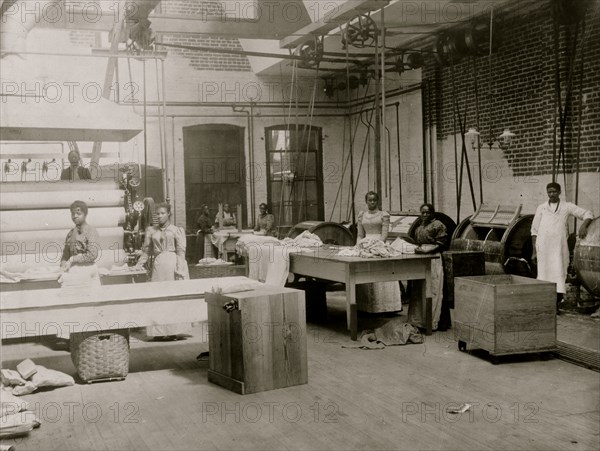 African American women and men posed by machinery, Lexington Laundry 1899